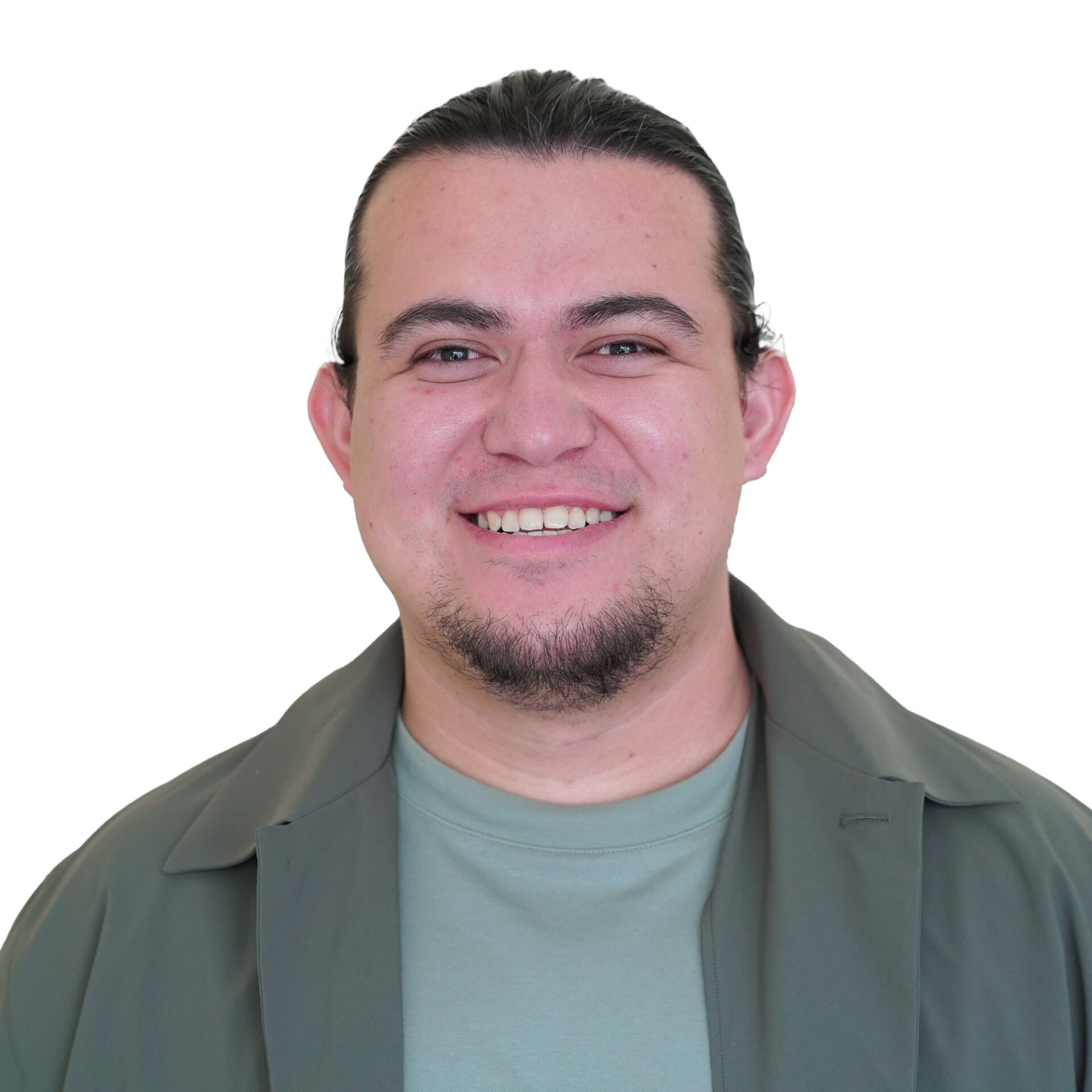 Danny has a warm smile, has his hair pulled back and sports chin facial hair and a khaki jacket